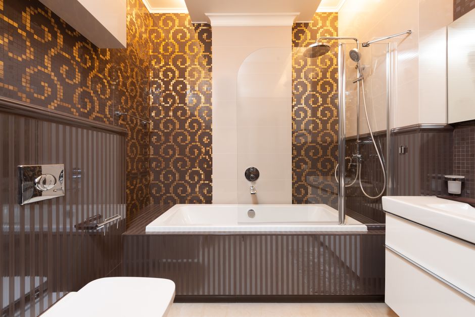 Elegant bathroom featuring a bathtub and mosaic-tiled walls in a contemporary design.