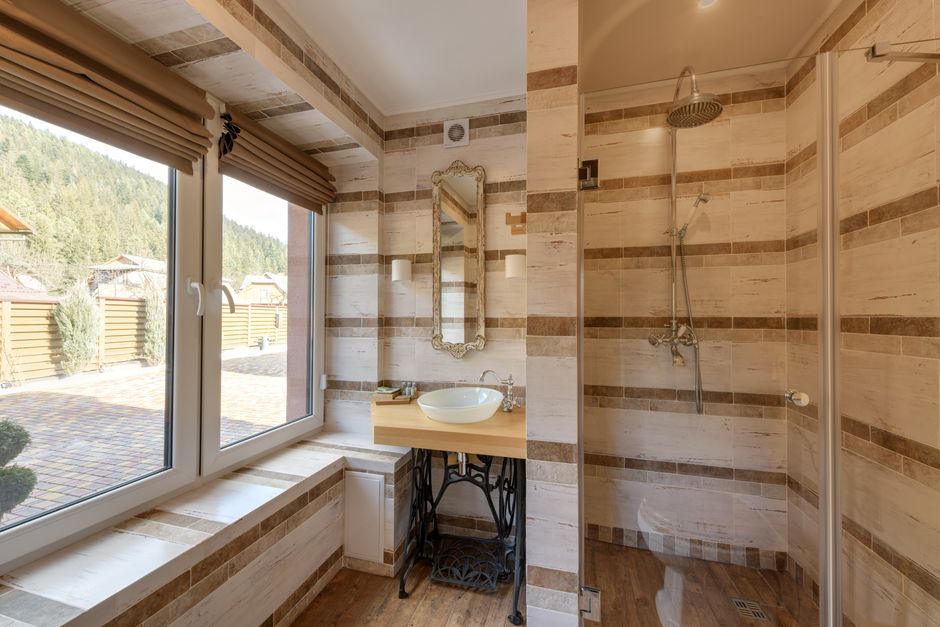 Stylish bathroom featuring a shower and mirror with natural light.