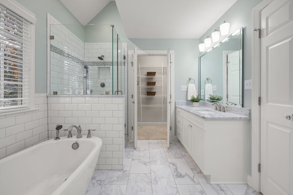 Elegant bathroom with white marble, glass shower, and bright lighting. Perfect for luxury home decor inspiration.