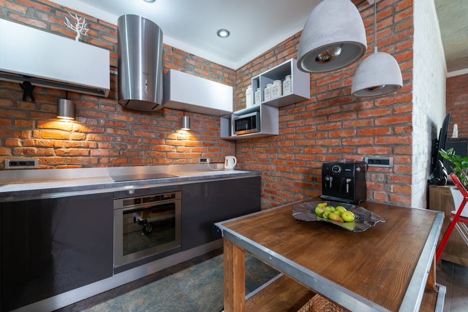 Contemporary kitchen interior featuring red brick walls and modern appliances.